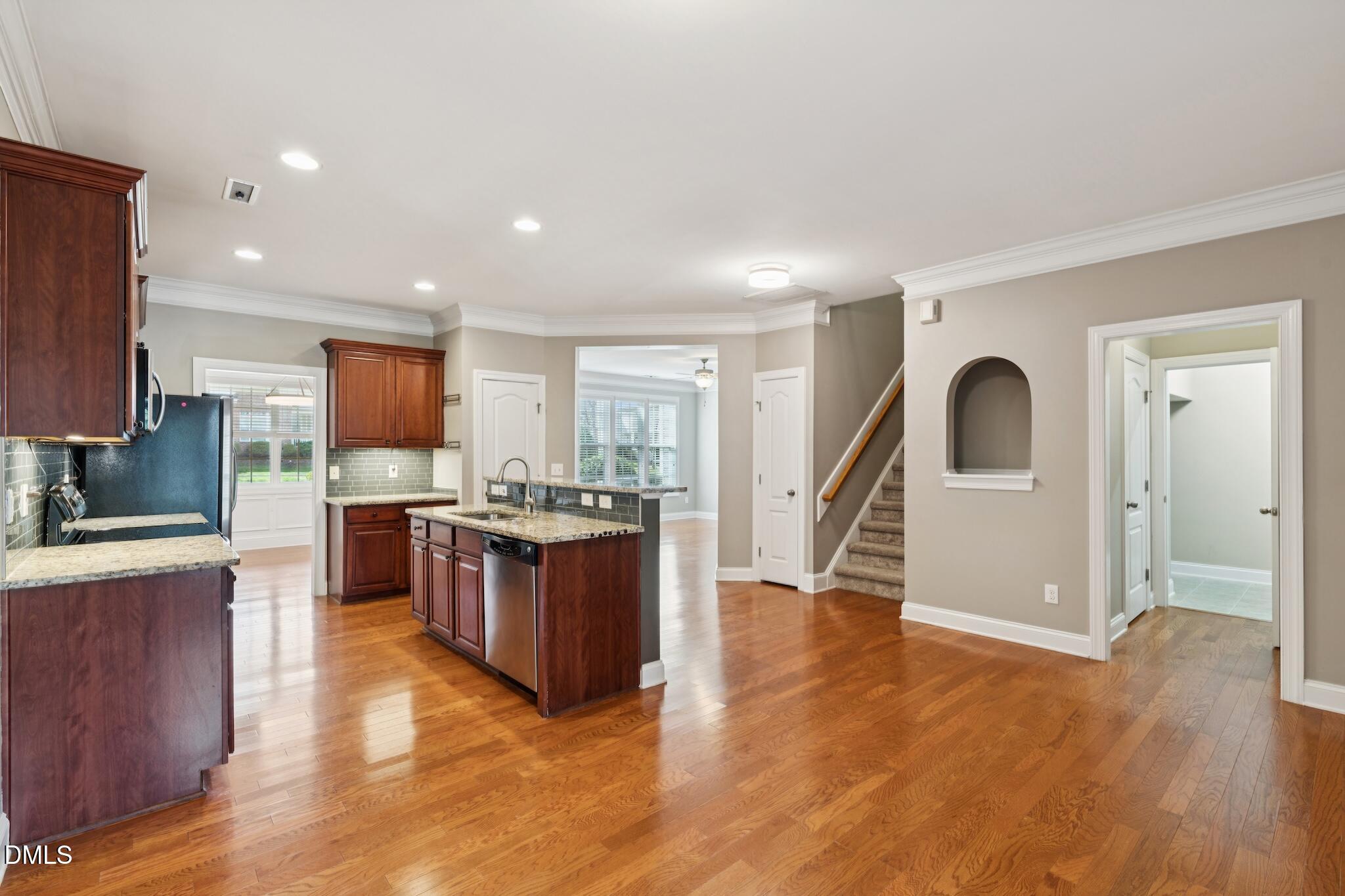 616 Democracy Street Raleigh, NC 27603 - Photo 23 of 61 a large kitchen with cabinets wooden floor stainless steel appliances and a window