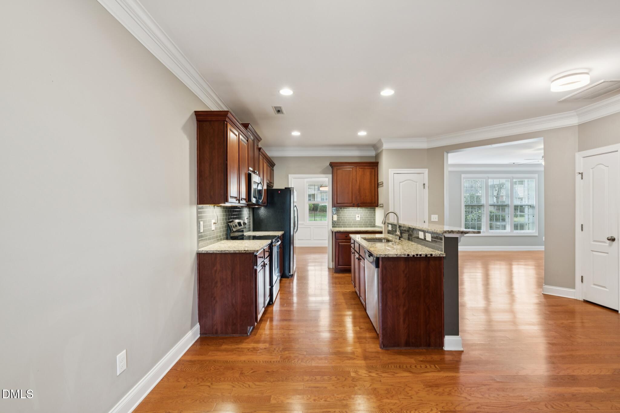 616 Democracy Street Raleigh, NC 27603 - Photo 25 of 61 a view of kitchen with stainless steel appliances granite countertop a stove top oven a sink and a refrigerator