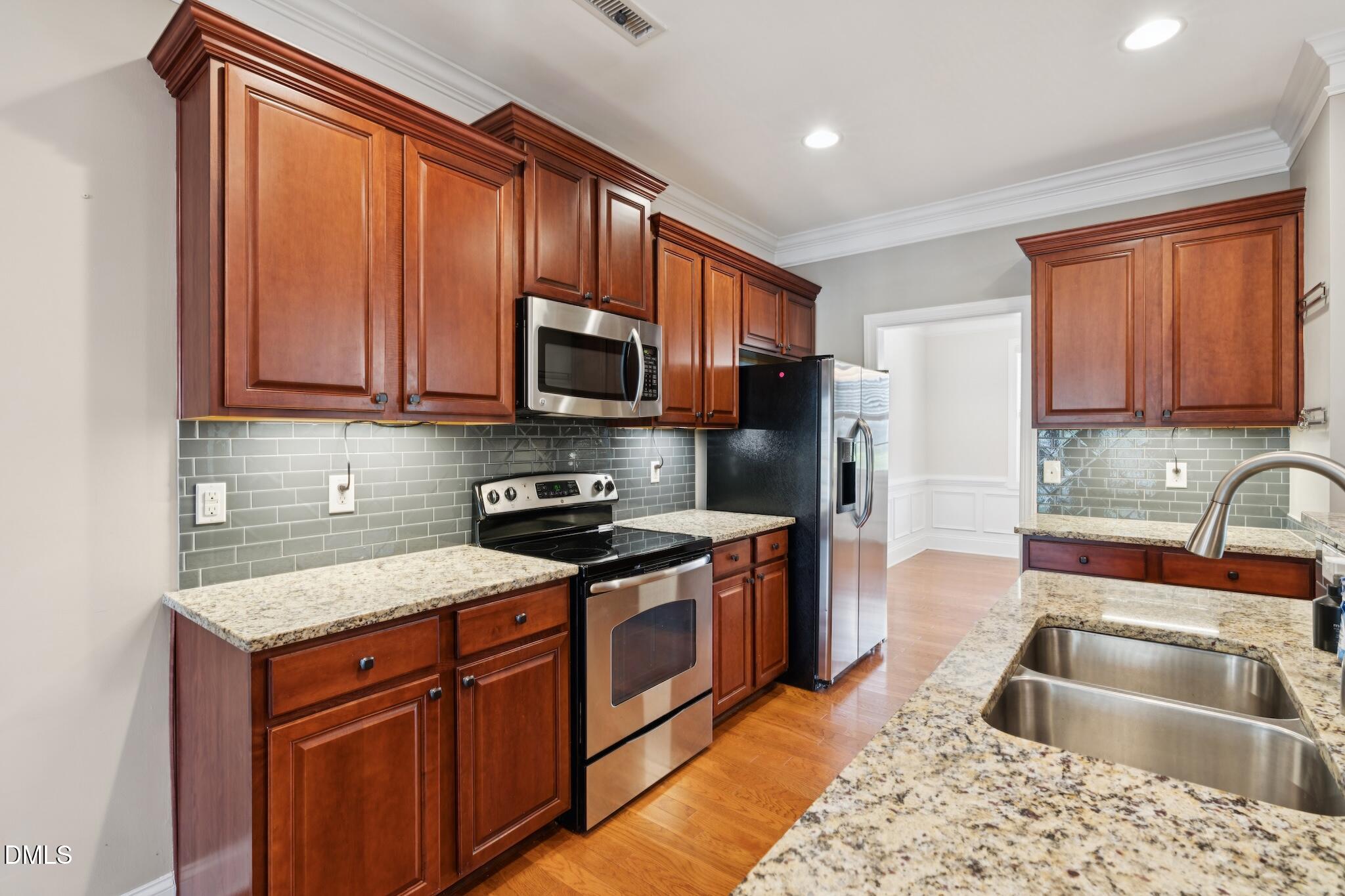 616 Democracy Street Raleigh, NC 27603 - Photo 28 of 61 a kitchen with stainless steel appliances granite countertop a sink stove microwave and refrigerator