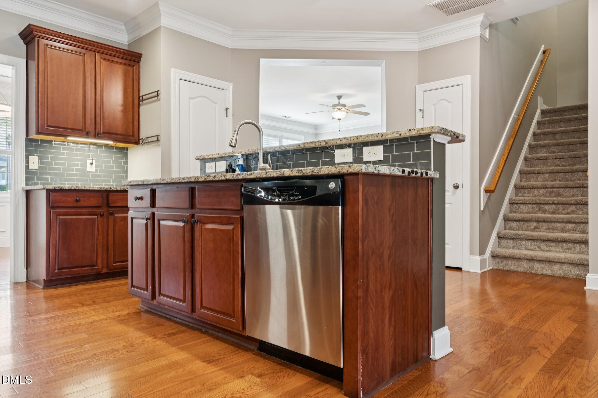 616 Democracy Street Raleigh, NC 27603 - Photo 30 of 61 a kitchen with granite countertop wooden cabinets and stainless steel appliances
