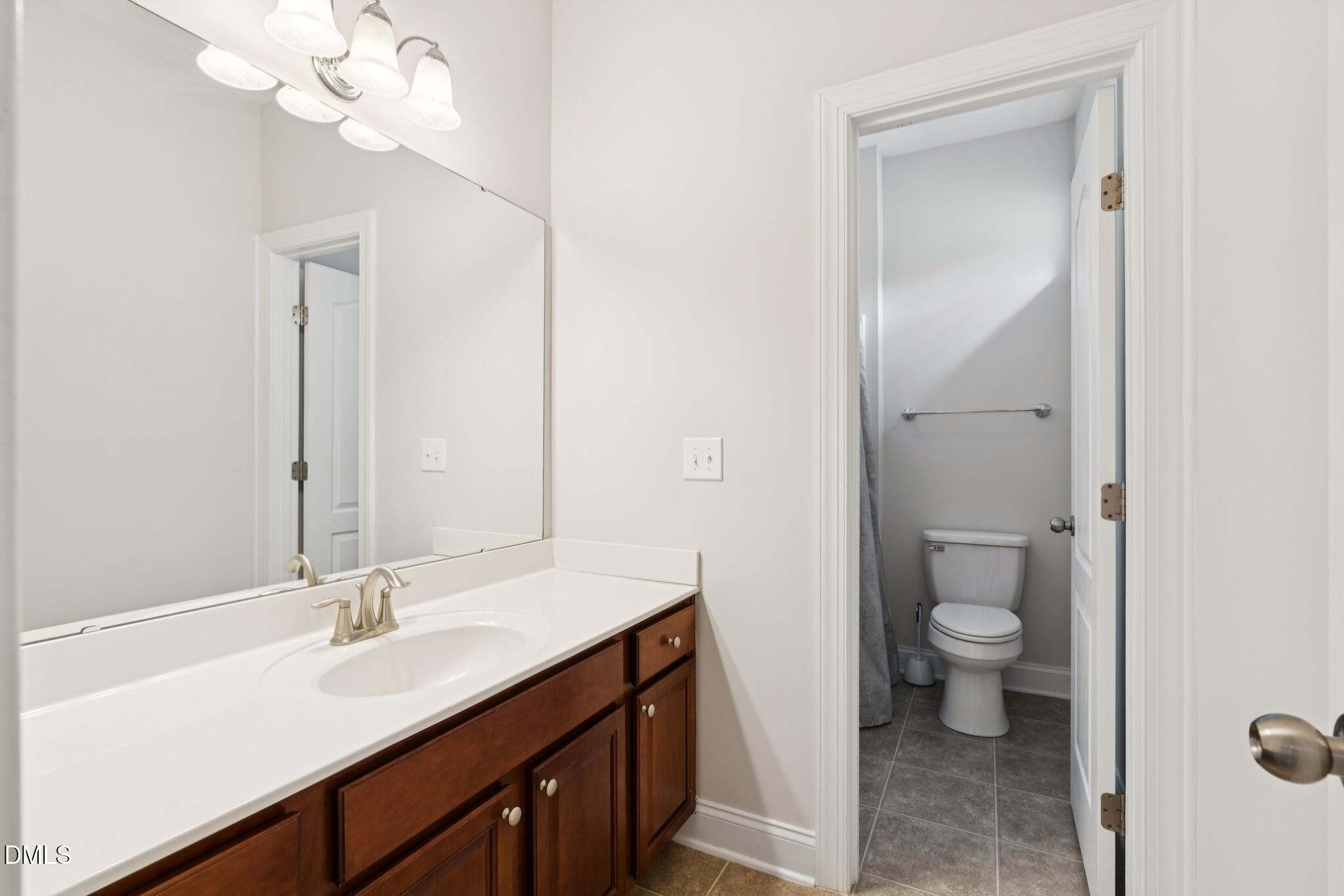 616 Democracy Street Raleigh, NC 27603 - Photo 37 of 61 a bathroom with a sink a toilet and a mirror