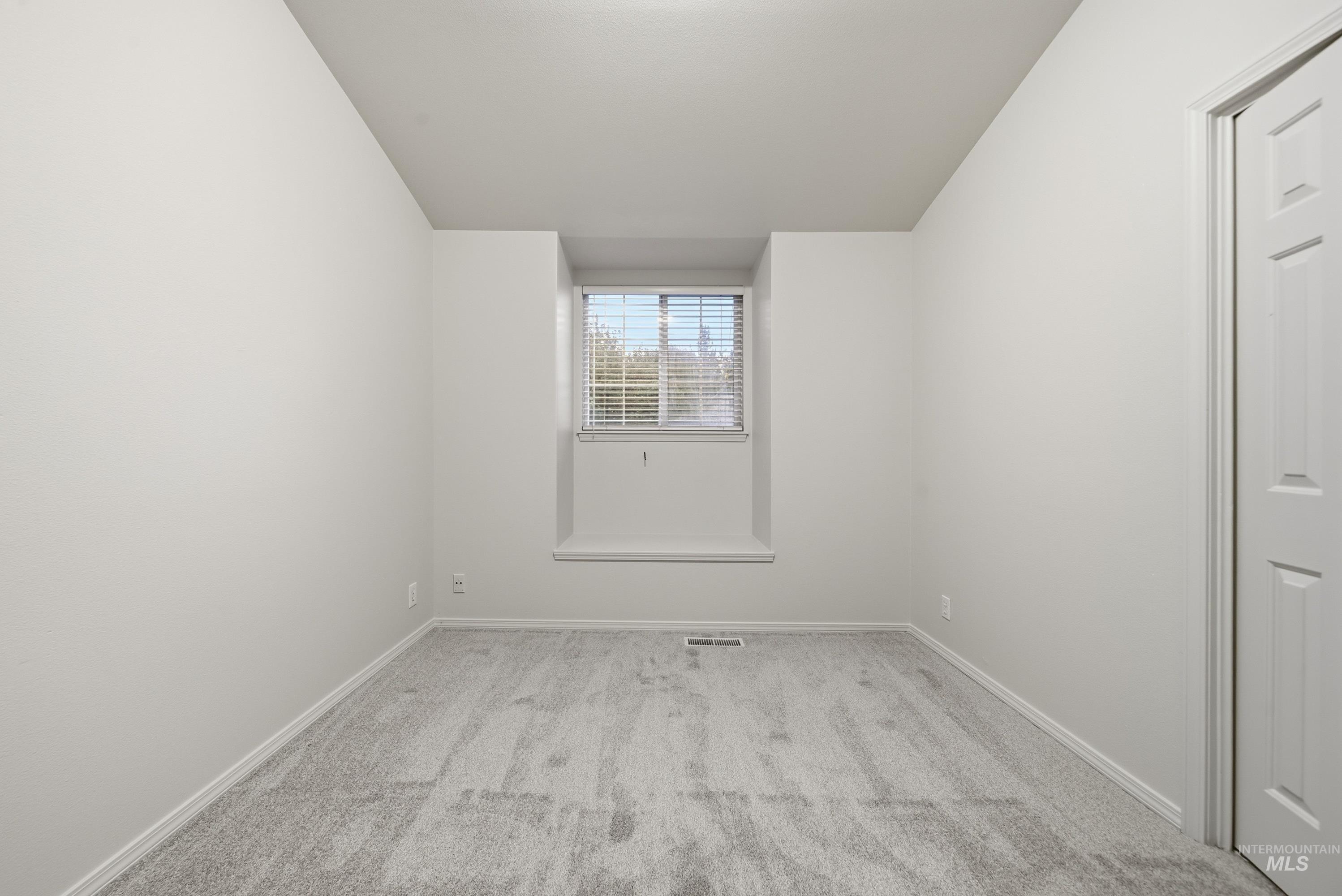 919 East Hawk Street Meridian, ID 83646 - Photo 20 of 31 Neutral-toned wall-to-wall carpeting, white painted walls, window with blinds, and white paneled door