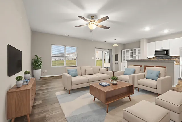 a living room with furniture a flat screen tv and a large window