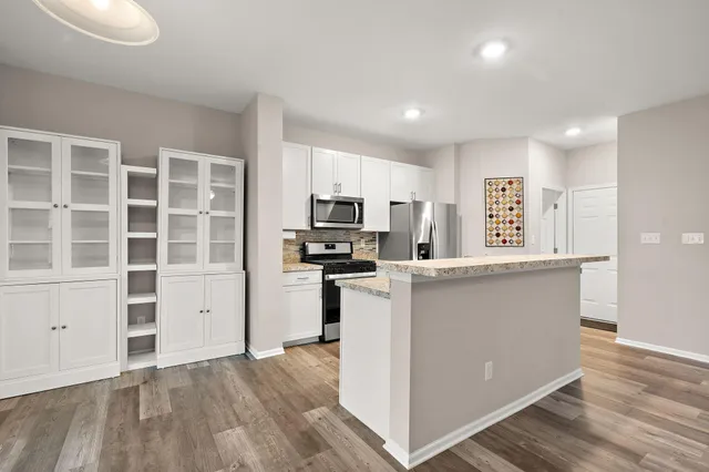 a kitchen with cabinets and wooden floor