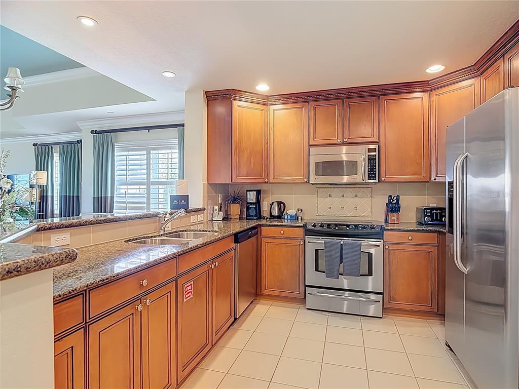 1116 Sunset View Circle, Unit 304 Reunion, FL 34747 - Photo 11 of 37 a kitchen with stainless steel appliances granite countertop a stove sink and cabinets