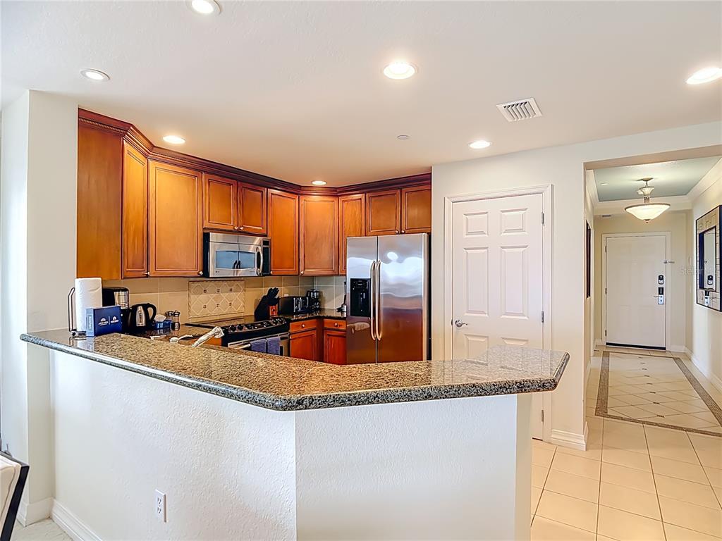 1116 Sunset View Circle, Unit 304 Reunion, FL 34747 - Photo 15 of 37 a kitchen with stainless steel appliances granite countertop a sink a stove and a refrigerator