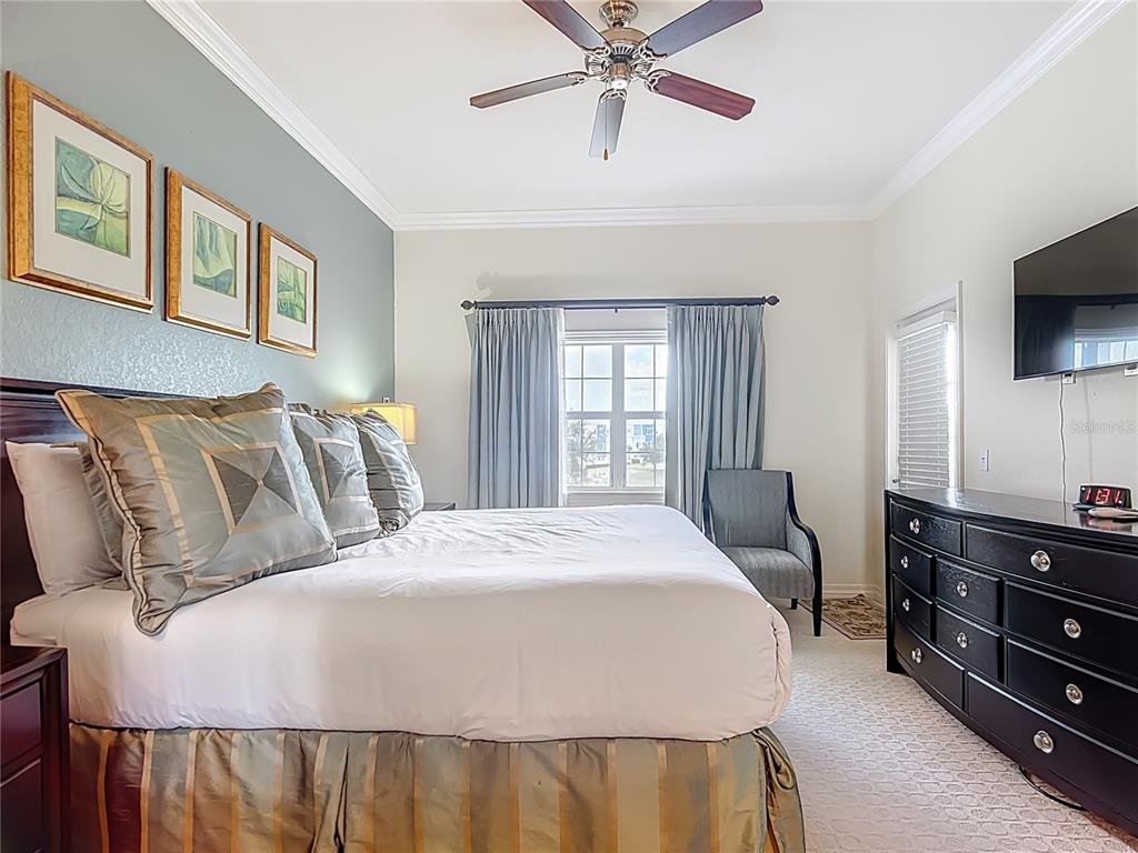 1116 Sunset View Circle, Unit 304 Reunion, FL 34747 - Photo 21 of 37 a bedroom with a bed a dresser and flat screen tv