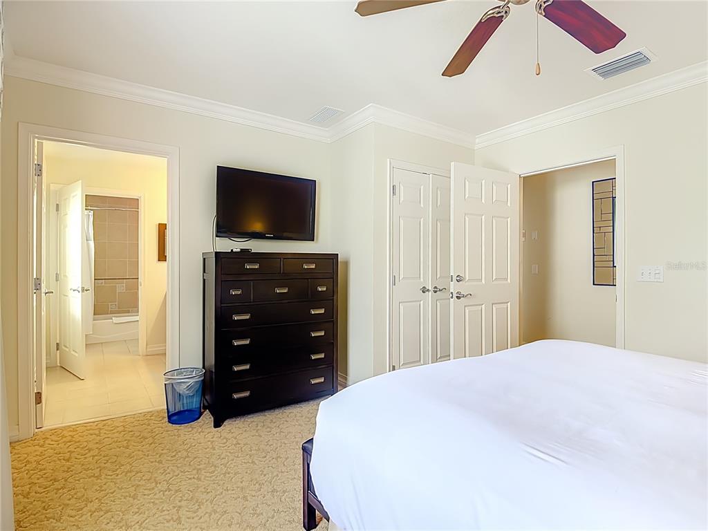 1116 Sunset View Circle, Unit 304 Reunion, FL 34747 - Photo 25 of 37 a bedroom with a bed and a flat screen tv