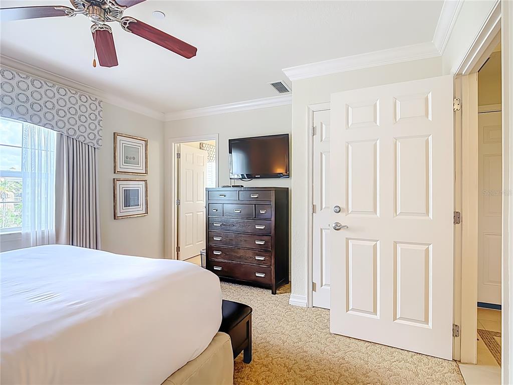 1116 Sunset View Circle, Unit 304 Reunion, FL 34747 - Photo 28 of 37 a spacious bedroom with a bed and a flat screen tv