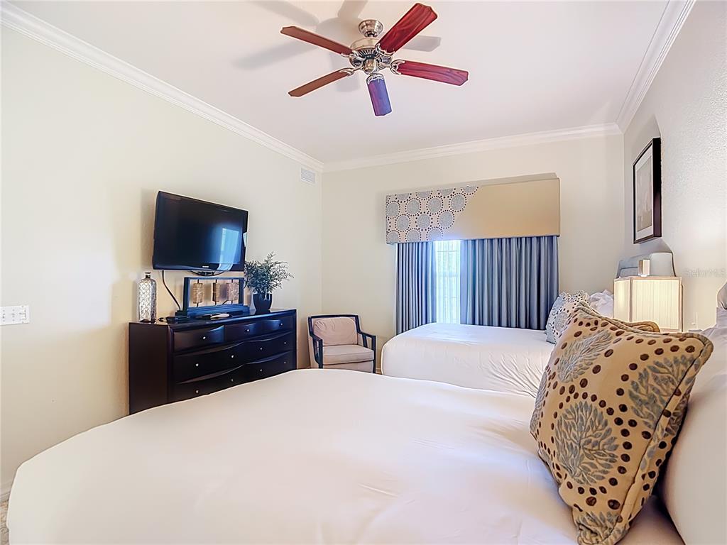 1116 Sunset View Circle, Unit 304 Reunion, FL 34747 - Photo 30 of 37 a bedroom with a bed and a flat screen tv