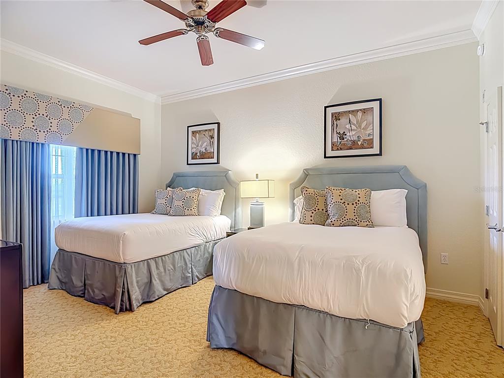 1116 Sunset View Circle, Unit 304 Reunion, FL 34747 - Photo 32 of 37 a bedroom with two beds and painting on the wall