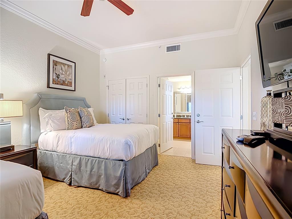 1116 Sunset View Circle, Unit 304 Reunion, FL 34747 - Photo 33 of 37 a bedroom with a bed and a flat screen tv