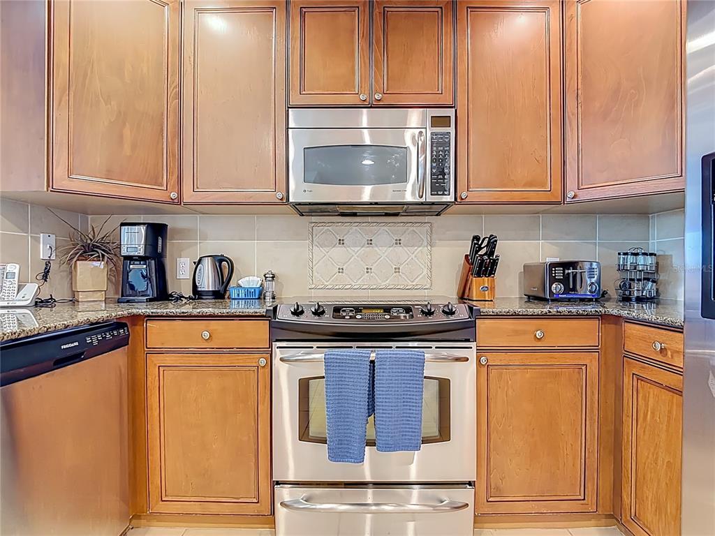 1116 Sunset View Circle, Unit 304 Reunion, FL 34747 - Photo 10 of 37 a kitchen with stainless steel appliances granite countertop a stove a sink and a microwave