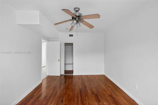 a view of empty room with wooden floor