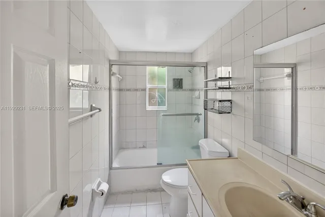 a bathroom with a granite countertop toilet sink and shower