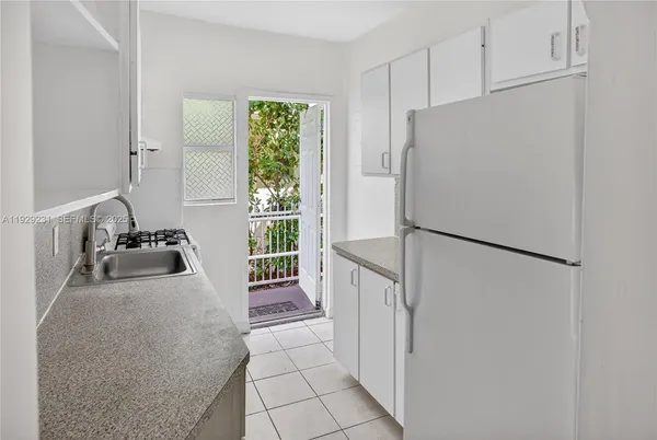 a white refrigerator freezer and a stove sitting inside of a kitchen
