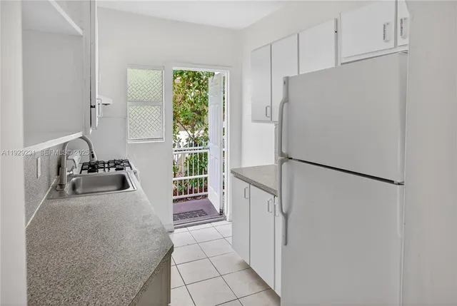 a white refrigerator freezer and a stove sitting inside of a kitchen