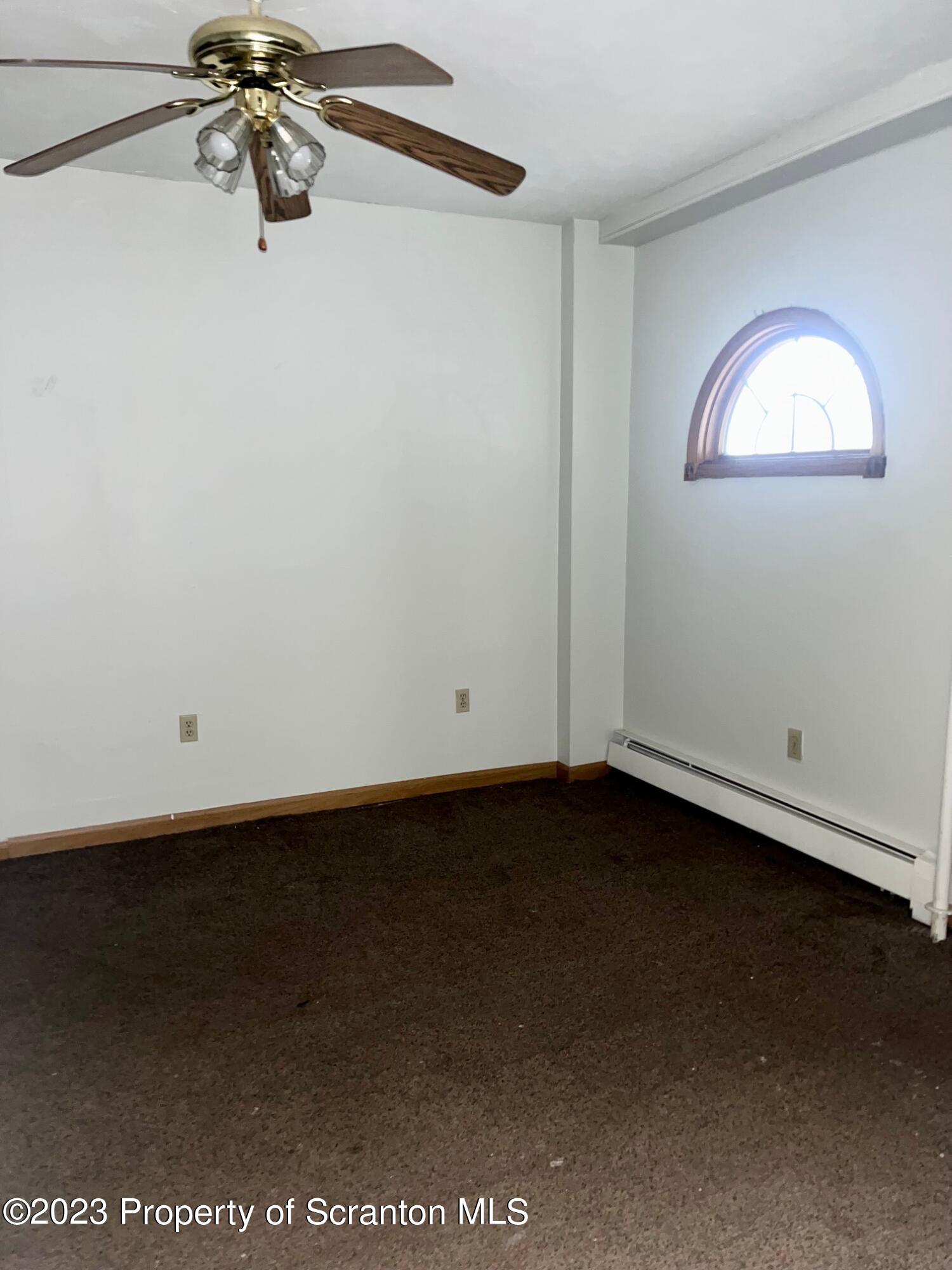 1803 Jackson Street Scranton, PA 18504 - Photo 5 of 8 an empty room with a ceiling fan and a window