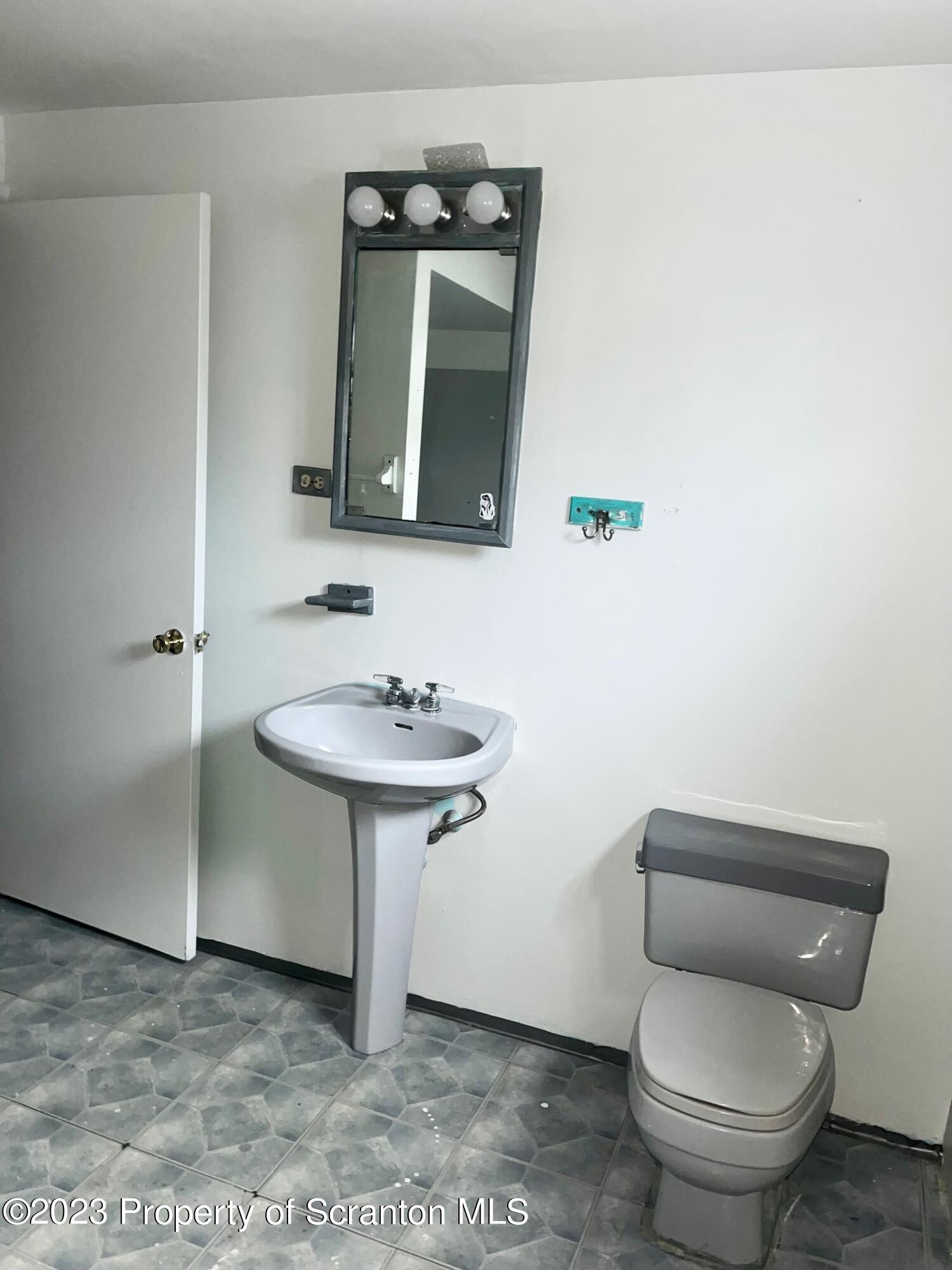 1803 Jackson Street Scranton, PA 18504 - Photo 8 of 8 a bathroom with a toilet sink and mirror
