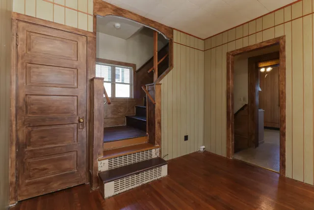a view of a hallway with wooden floor and closet area
