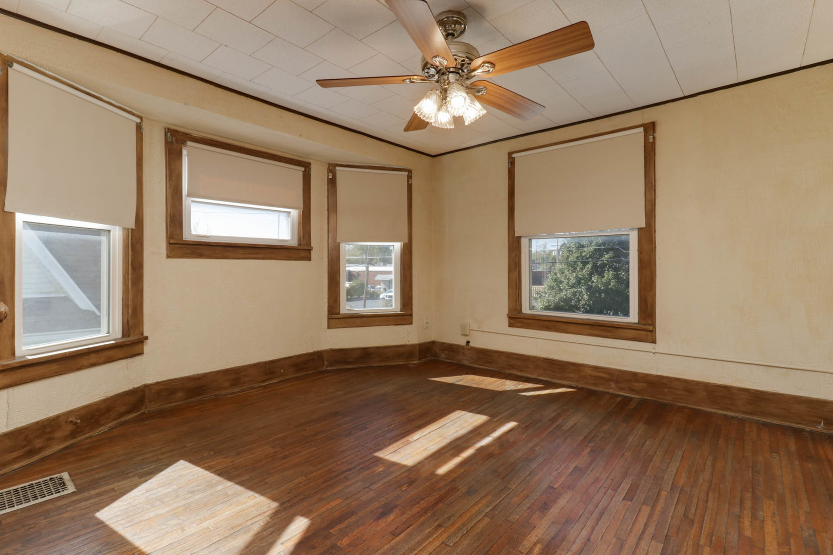 506 South Denver Street Bloomington, IL 61701 - Photo 17 of 41 an empty room with wooden floor chandelier fan and windows