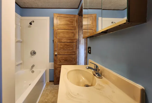 a bathroom with a tub sink and mirror