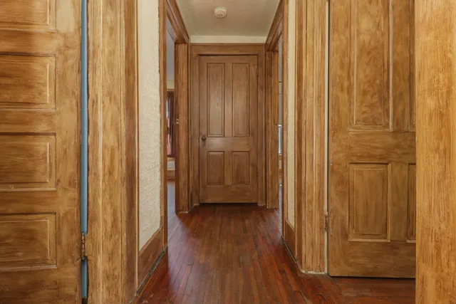 a view of a hallway with wooden floor