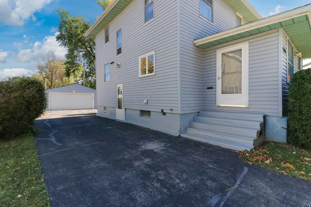 a view of a house with a yard and large tree
