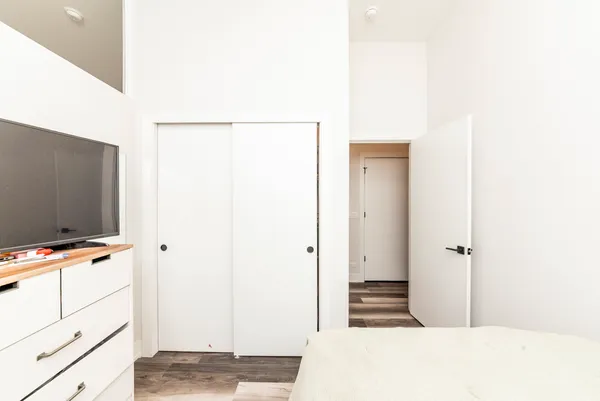 a bedroom with a bed and a flat screen tv