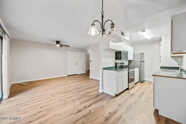 a kitchen with granite countertop a stove a sink and a wooden floor