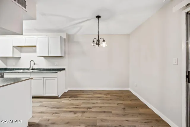 a kitchen with granite countertop white cabinets and white appliances