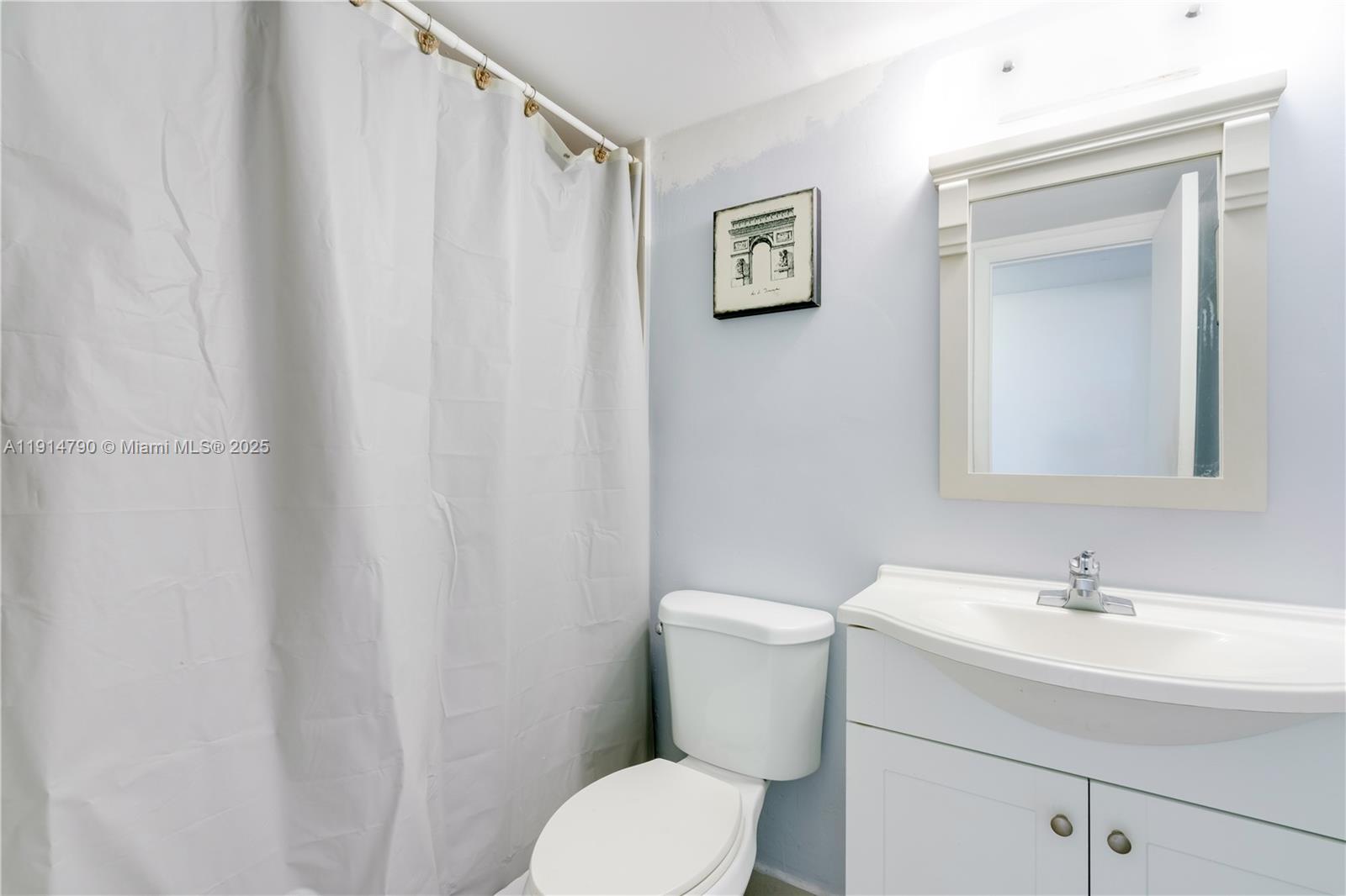 9423 Southwest 76th Street, Unit W21 Miami, FL 33173 - Photo 7 of 20 a bathroom with a toilet sink and mirror