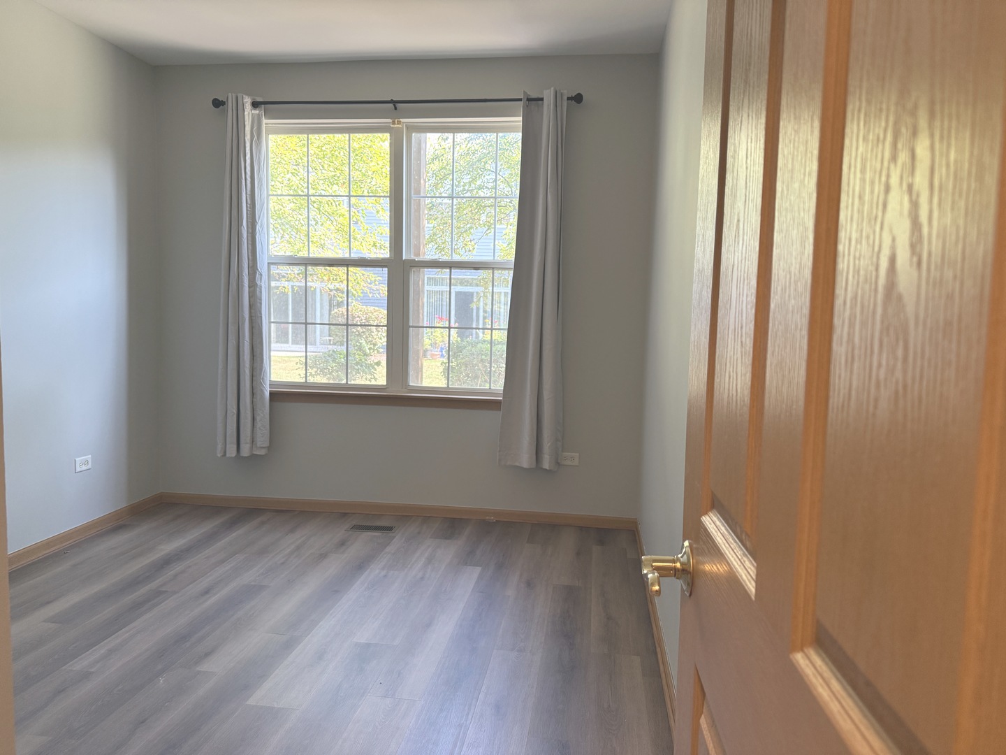 810 Woodewind Drive, Unit 810 Naperville, IL 60563 - Photo 12 of 16 an empty room with wooden floor and a window