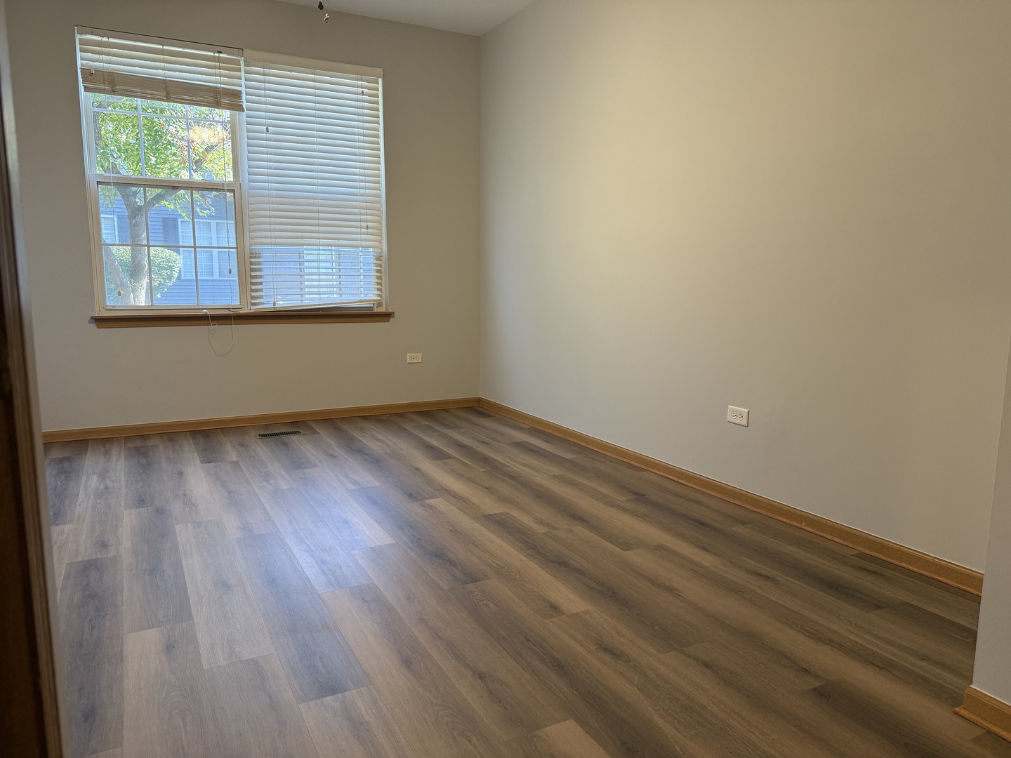 810 Woodewind Drive, Unit 810 Naperville, IL 60563 - Photo 14 of 16 an empty room with wooden floor and windows