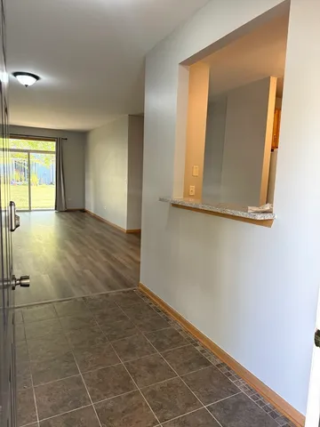 a view of an empty room with window and bathroom