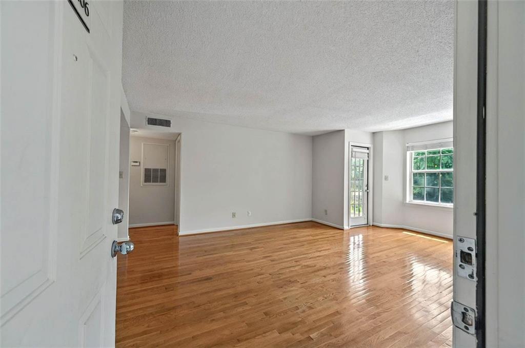 4106 Chastain Park Court Northeast Atlanta, GA 30342 - Photo 6 of 33 a view of an empty room with window and wooden floor
