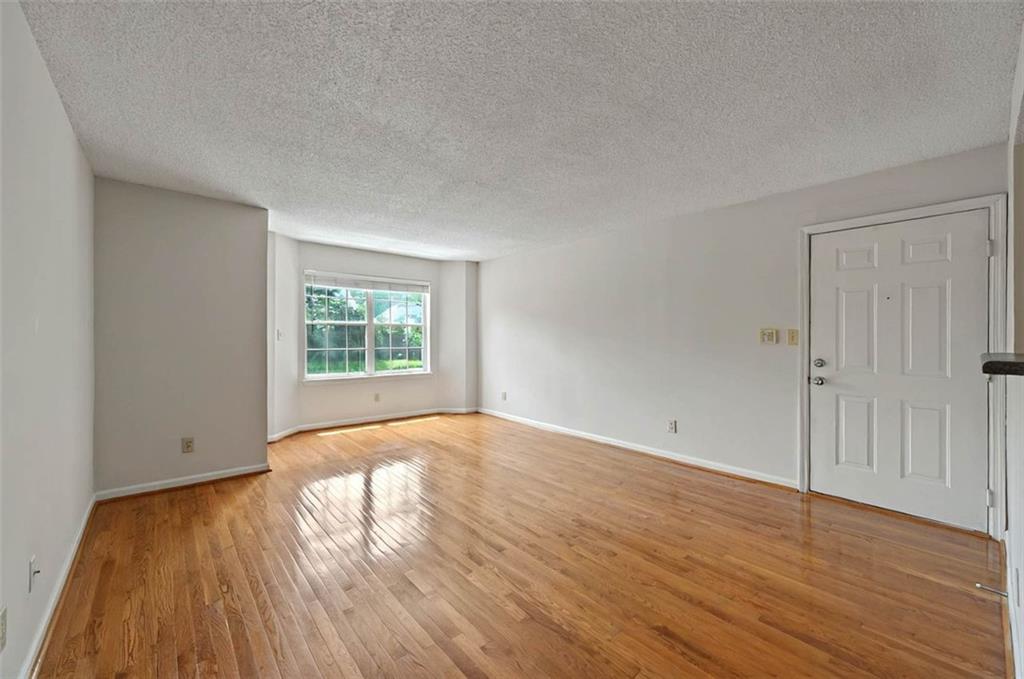 4106 Chastain Park Court Northeast Atlanta, GA 30342 - Photo 7 of 33 an empty room with wooden floor and windows