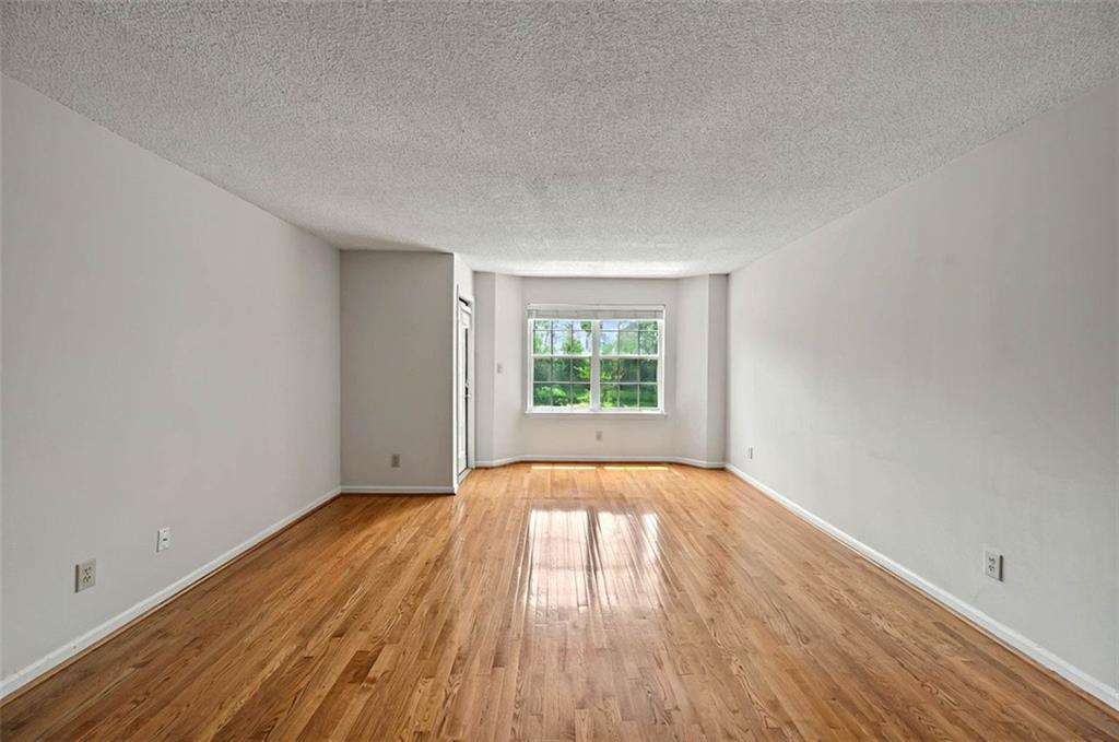 4106 Chastain Park Court Northeast Atlanta, GA 30342 - Photo 8 of 33 an empty room with wooden floor and windows