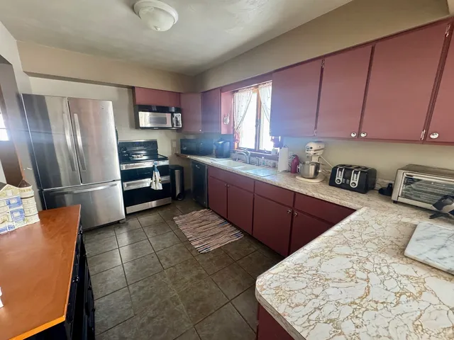 a kitchen with stainless steel appliances kitchen island granite countertop a sink counter space and cabinets