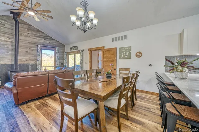 a view of a dining room with furniture a chandelier and wooden floor