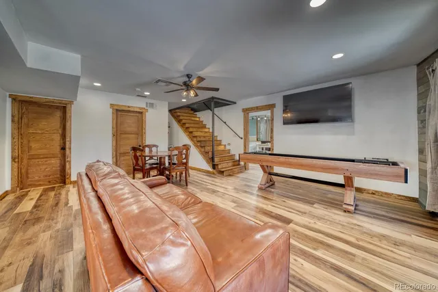 a view of an empty room with furniture wooden floor and windows