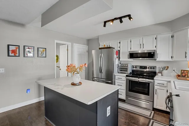 a kitchen with refrigerator cabinets and wooden floor