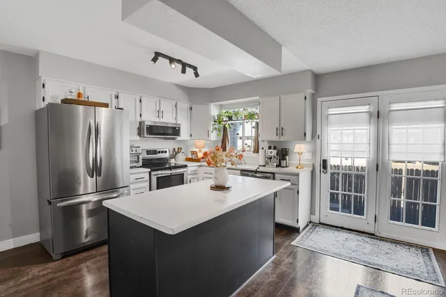 a kitchen with a refrigerator a sink and a stove top oven