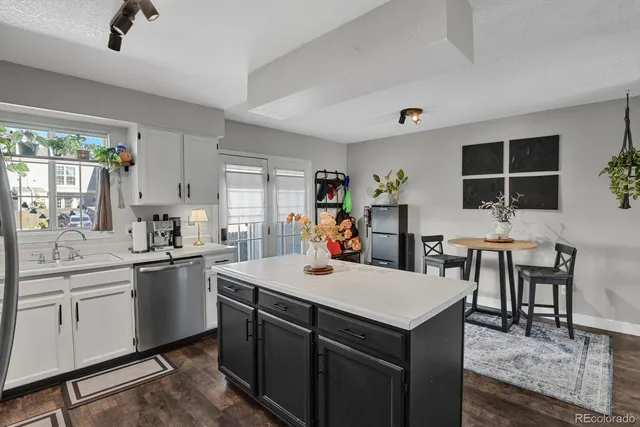 a kitchen with a stove a sink dishwasher and a refrigerator with wooden floor