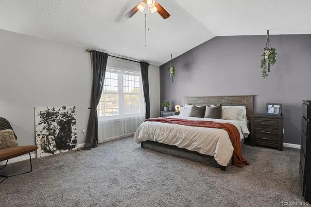 a spacious bedroom with a bed and a chandelier