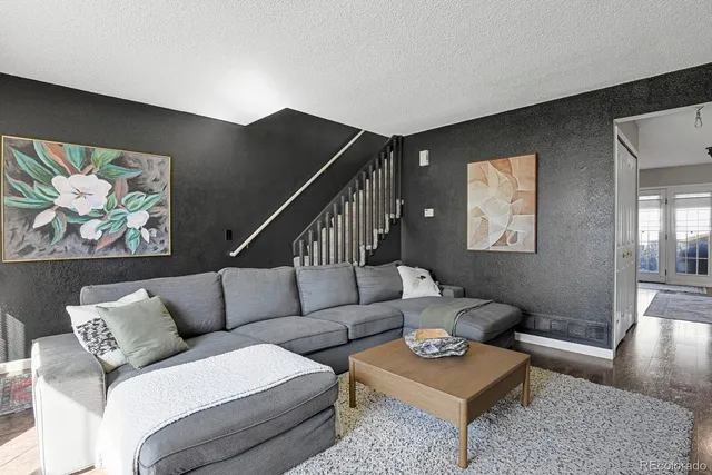 a living room with furniture and a wooden floor