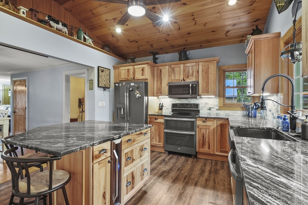 8 Beach Road Shrewsbury, MA 01545 - Photo 8 of 40 a kitchen with stainless steel appliances granite countertop a stove refrigerator a sink dishwasher a dining table and chairs with wooden floor