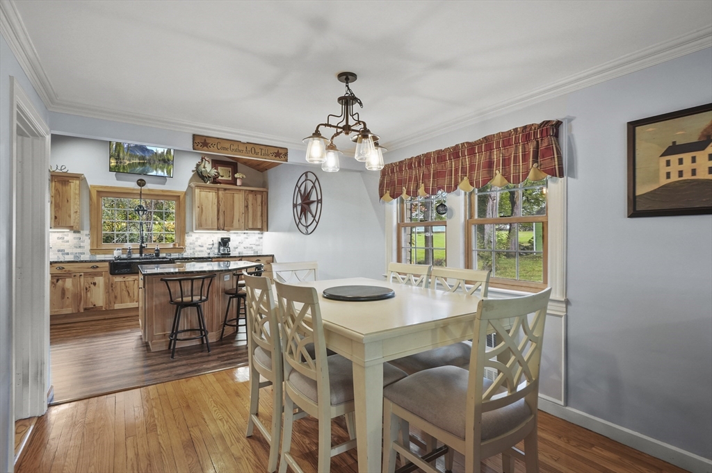 8 Beach Road Shrewsbury, MA 01545 - Photo 9 of 40 a dining room with wooden floor a chandelier a wooden table and chairs