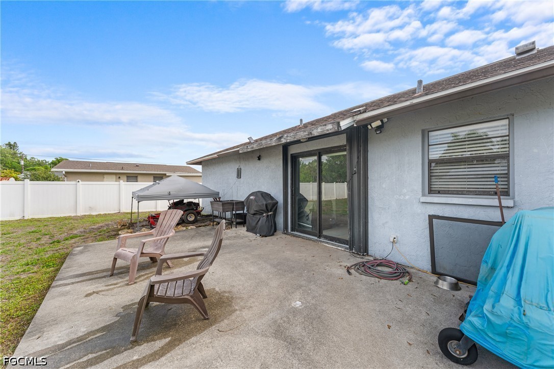 2239 Lotus Road Fort Myers, FL 33905 - Photo 18 of 26 a view of a patio with table and chairs a barbeque with wooden fence