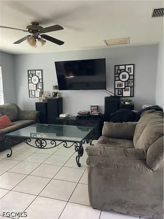 a living room with furniture a flat screen tv and a window